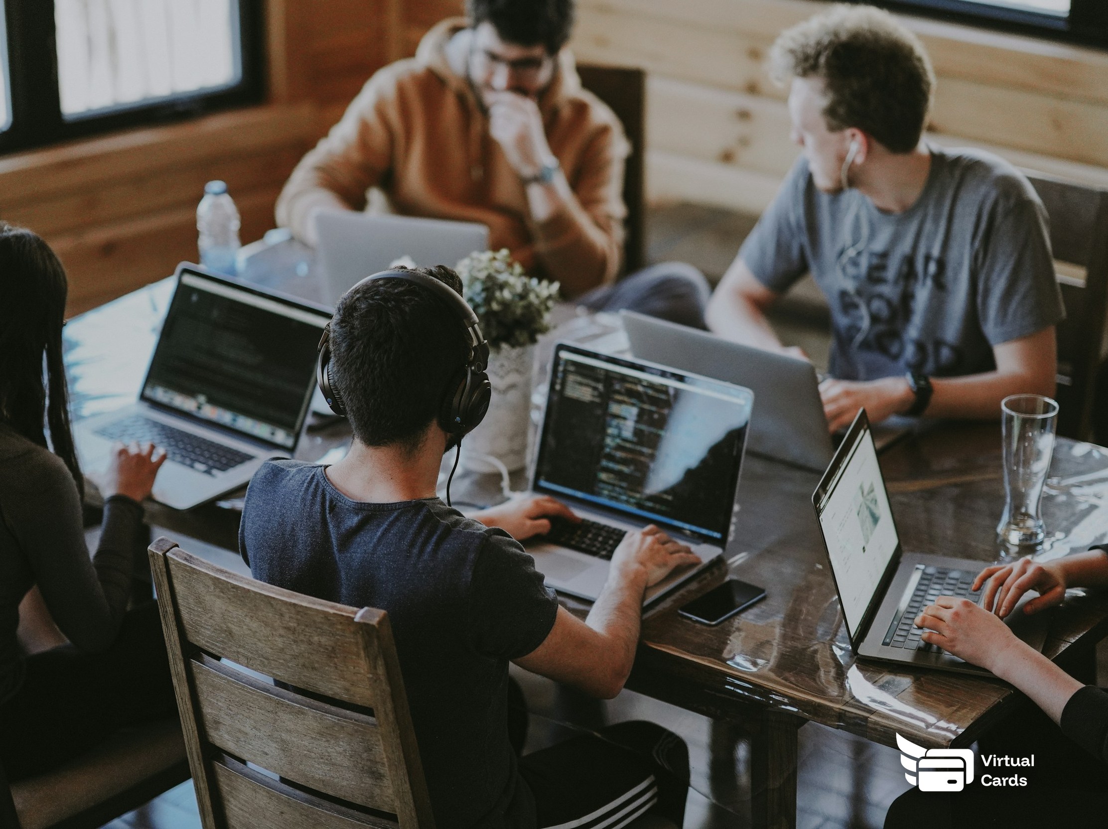 A creative team working together on laptops around a table.