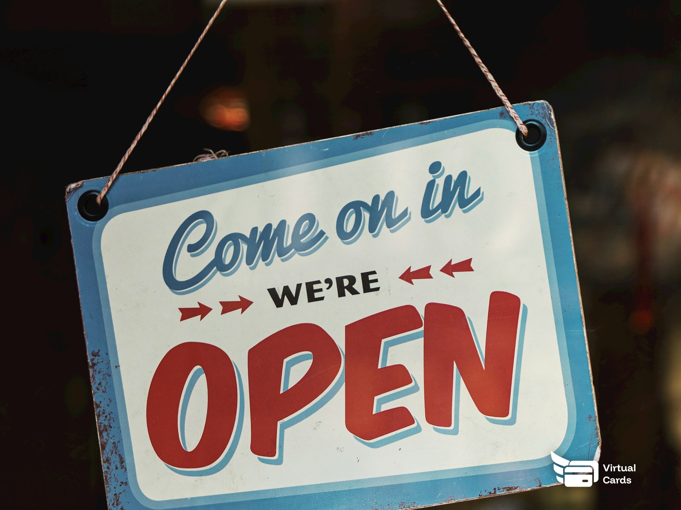 An open sign hanging in the window of a small shop.