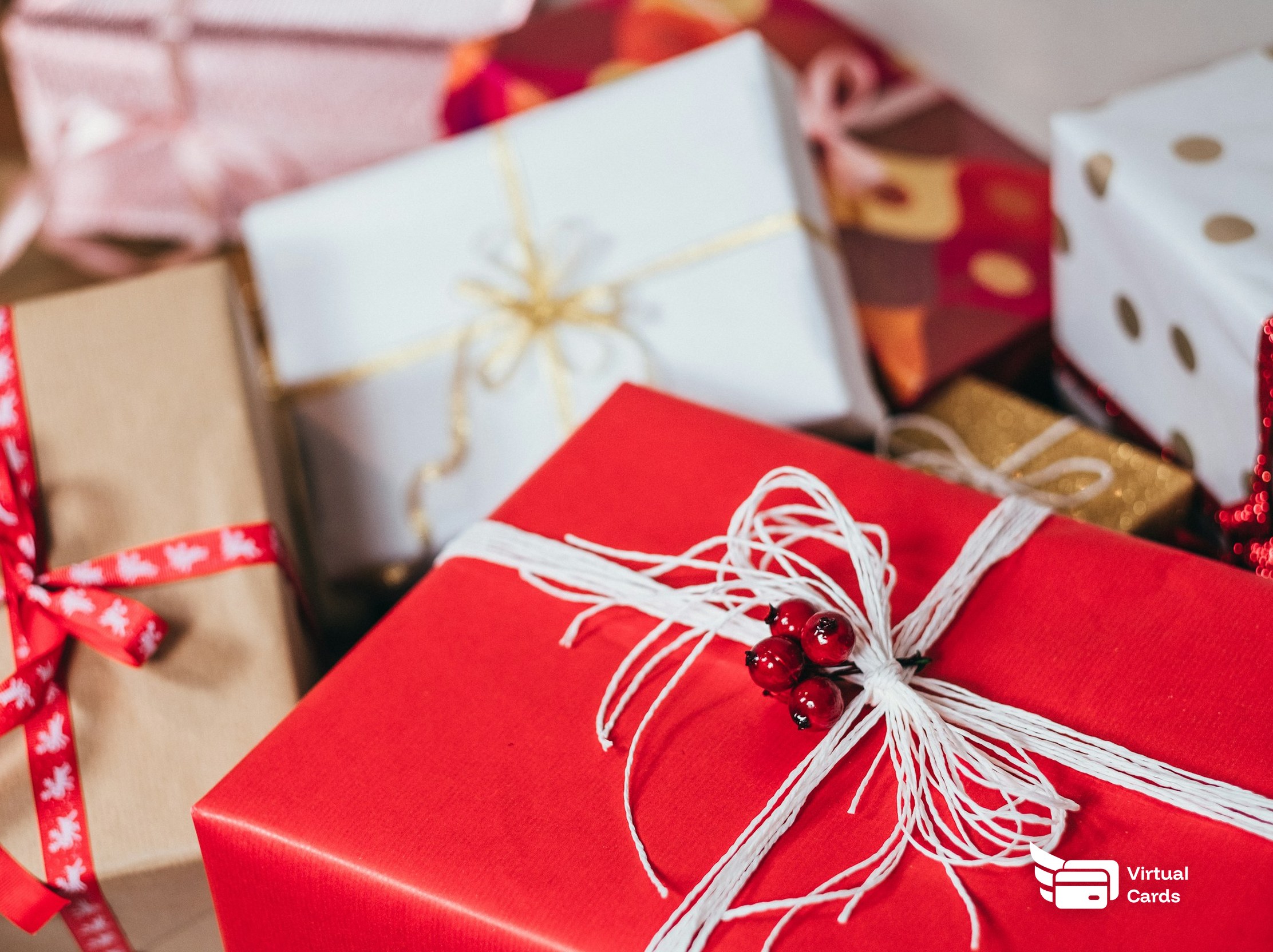 A pile of wrapped gift boxes with ribbons, representing employee gift cards sent as virtual Visa cards.