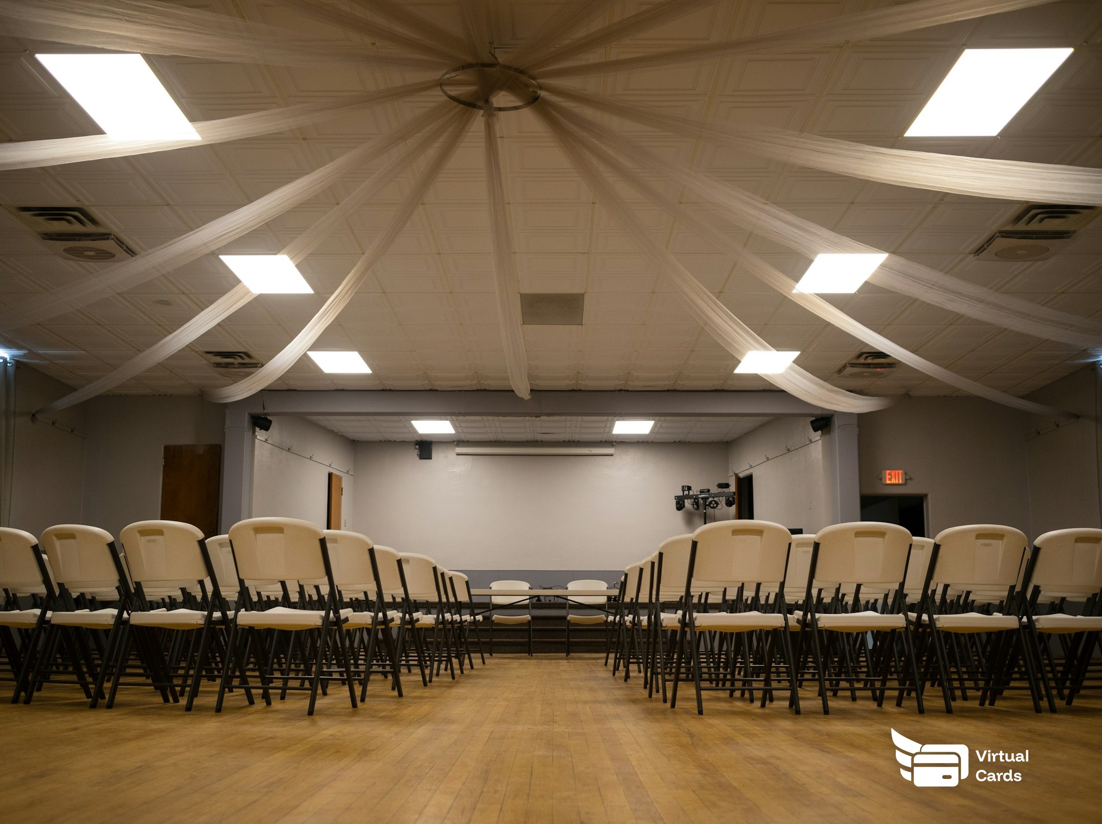 Rows of empty seats in a bright conference hall, representing event and conference spend managed on per-event virtual Visa cards.