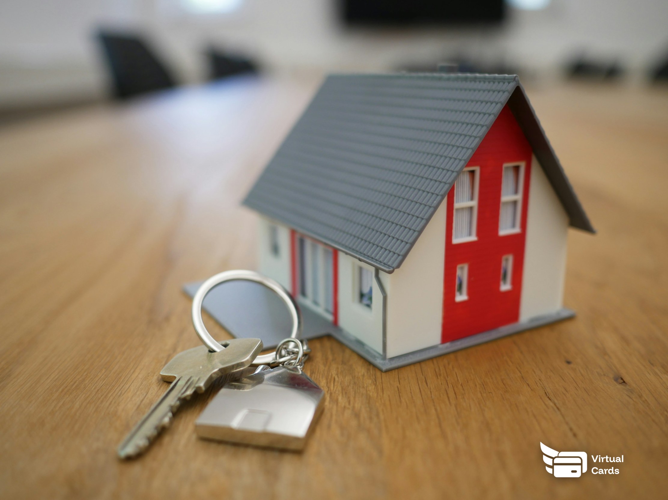 A model house and a set of keys on a wooden table.