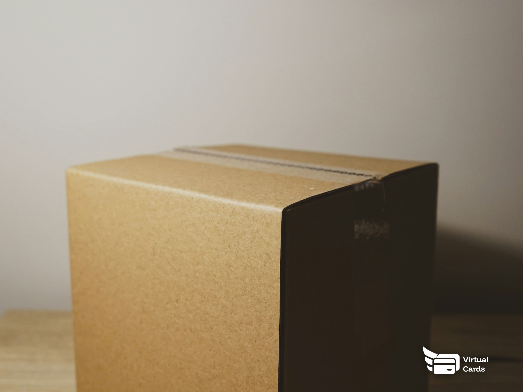 A sealed brown cardboard parcel on a desk, representing a return.