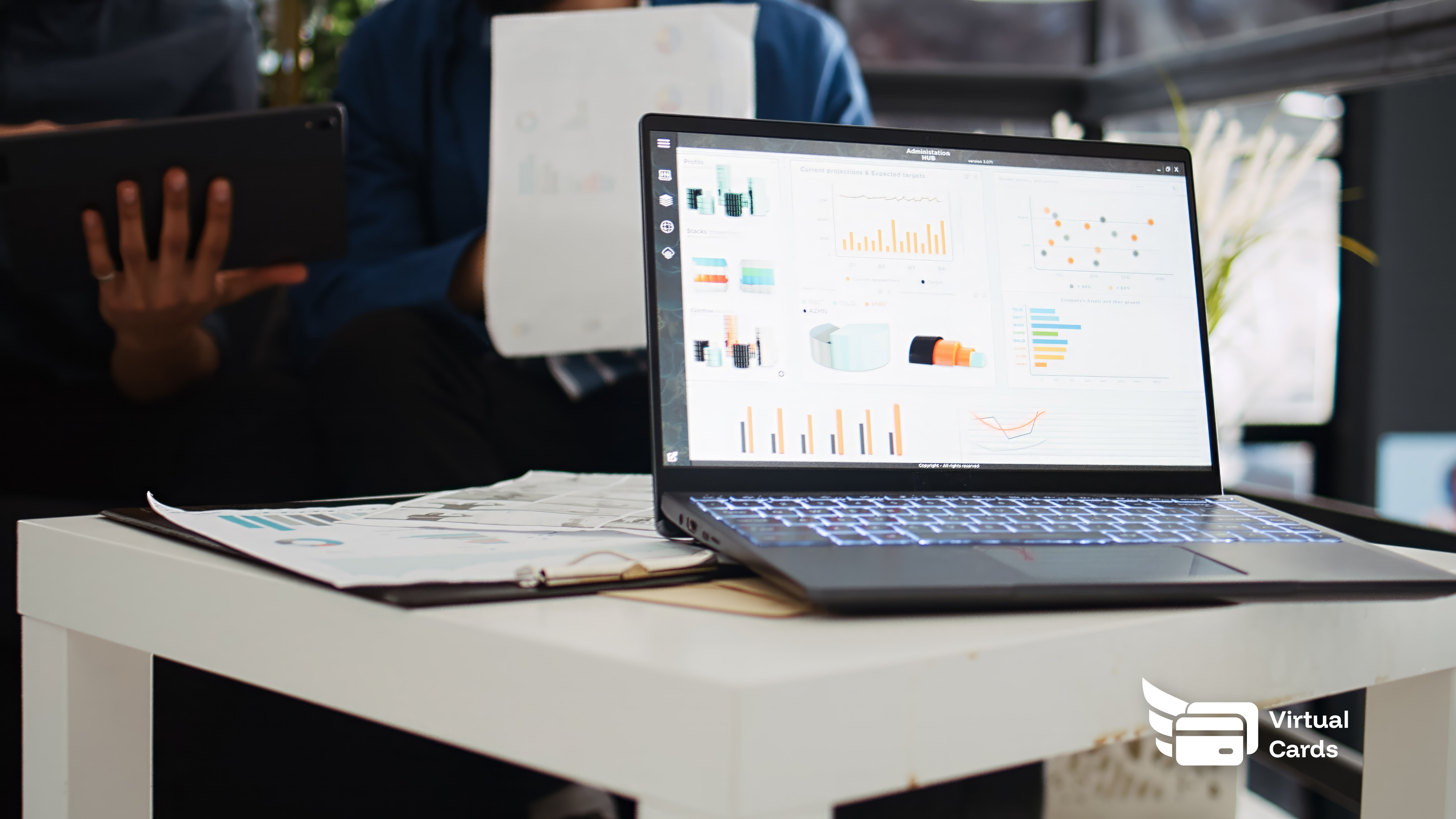 Two coworkers at a laptop reviewing a list of software subscriptions, identifying unused tools to cancel and reduce their monthly software bill.