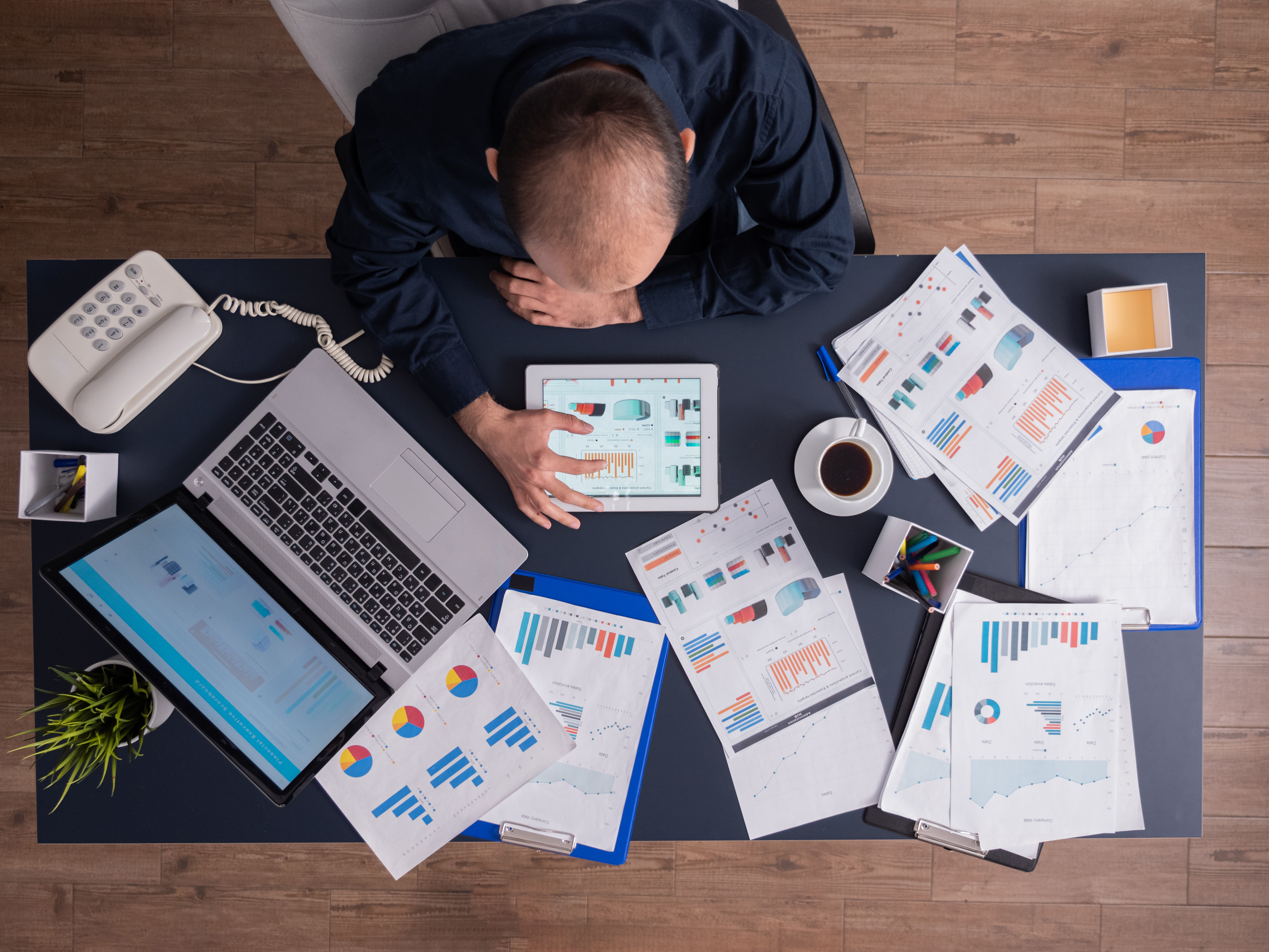 Business analyst reviewing financial reports and charts spread across a desk