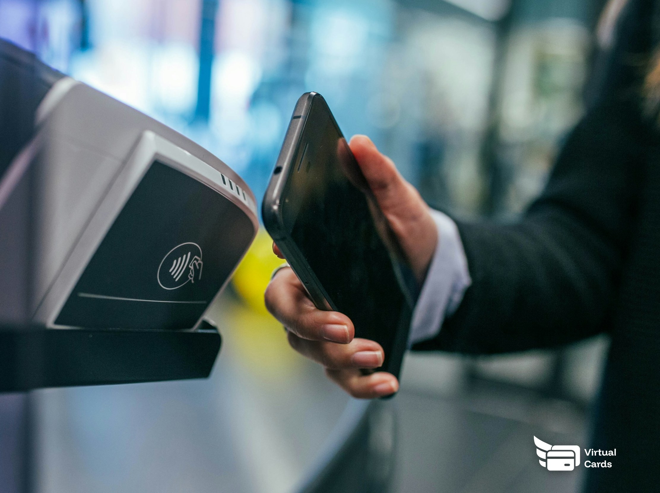 A person making a contactless payment by tapping a smartphone on a card reader.