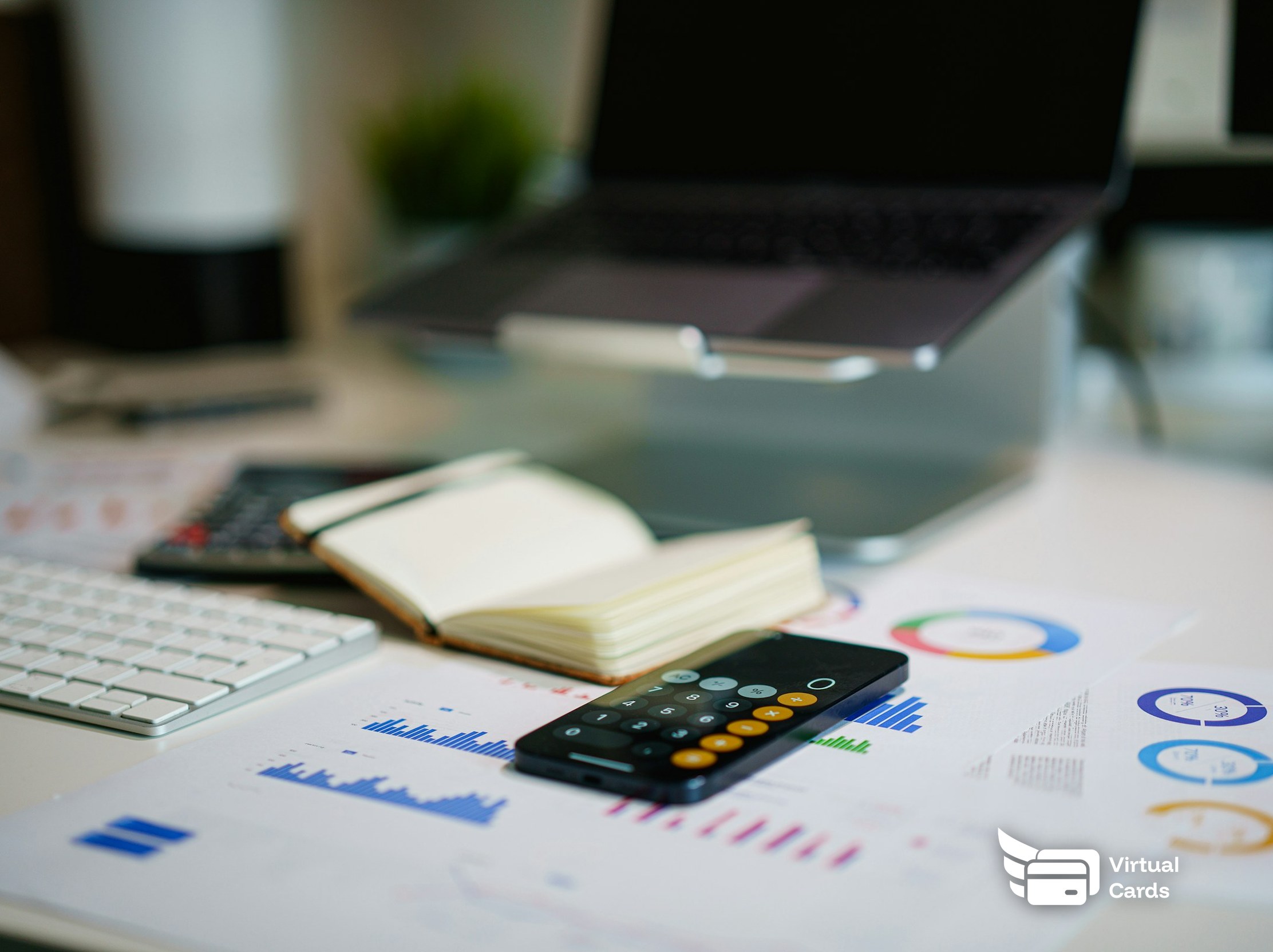 A desk with financial charts, a calculator, and a notebook, representing how to manage law firm expenses with a virtual card